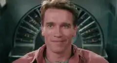 Arnold Schwarzenegger looks up and smiles