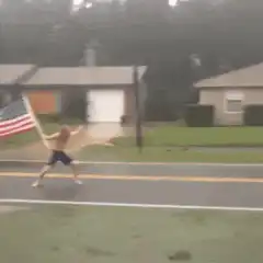 Man waving American flag in rain
