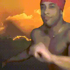 shirtless man in red bandana sunset