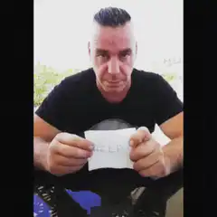 Man holding a note that says HELP