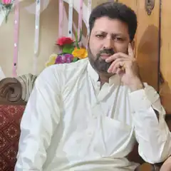 Man in white kurta resting chin on hand