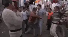 Man in suit dodging punches in market