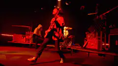Guitarist plays on red stage
