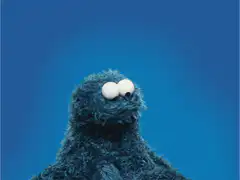 Cookie Monster holds a red heart