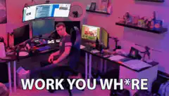 Guy sitting at desk pointing at camera