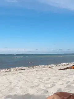 Beach scene with people swimming and sunbathing
