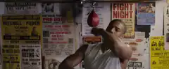 Man shadow boxing in front of posters