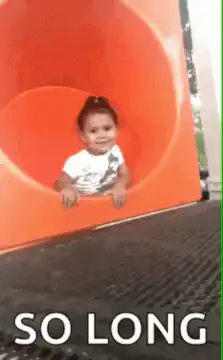 Toddler slides down orange tube