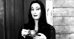 Morticia Addams sipping tea