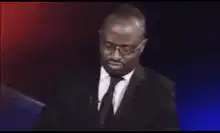 Man in suit looking down then up