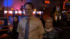 Dwight adjusts his tie in the arcade