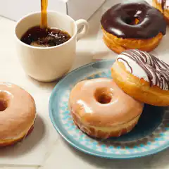 coffee pouring into cup with donuts