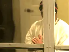 Man praying behind glass door