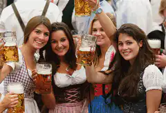 Women in dirndls drinking beer at Oktoberfest