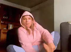 Girl in pink hoodie does a leg stretch