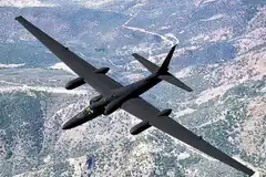 Black U-2 spy plane flying over mountains