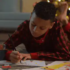 Boy writing Dear Santa letter