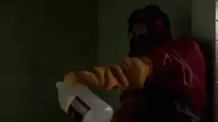 man pours liquid on gun in sink