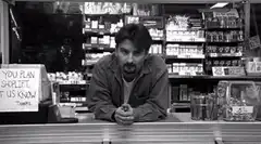 Man slumps on counter in black and white