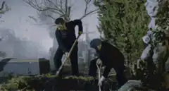 Two men digging a grave in a cemetery