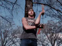 man throwing axe at tree