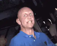 Bald man in blue shirt dancing excitedly