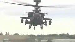 Apache helicopter flying through explosions