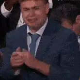 Man in suit crying and clapping