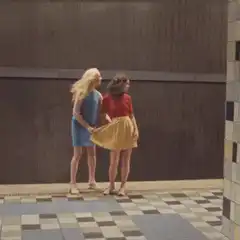Two women on subway platform skirt blows up