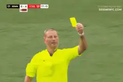 Soccer player holds up yellow card