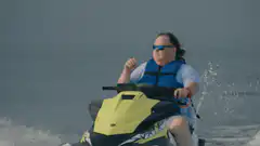 Woman on jet ski removes sunglasses
