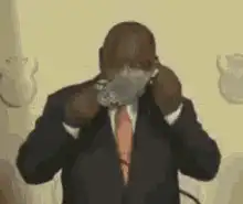 Man in suit puts on patterned face mask