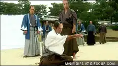 Man in white kimono bows deeply