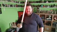 Man with lightsaber in toy room