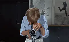 Man looks through camera and reacts