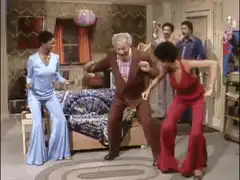 Bill Cosby dancing with two women