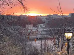 sunset over city with lit street lamp