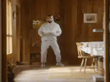 Bearded man in white sweatsuit dancing