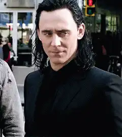 Loki smirking in black suit