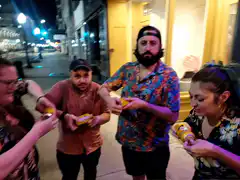 Friends drinking from cans on street at night