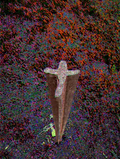Rusty metal cross in grass