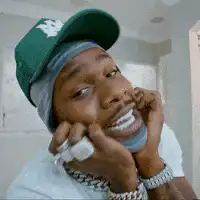 Man in green hat touching his face