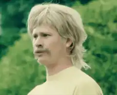 Man with mustache and mullet talking