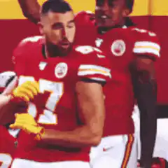 Travis Kelce flexing in red jersey