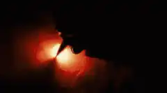 Hand lighting a candle with a match