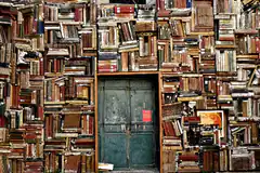 wall of old books with green door