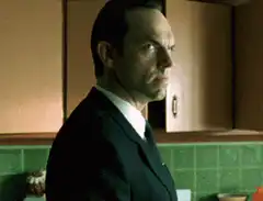 Agent K turns and smiles creepily