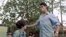 Tall man slaps short man on the head