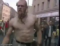Shirtless man dancing on street