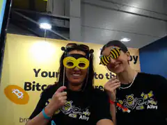 Two women wearing bee glasses at Alby Bitcoin booth